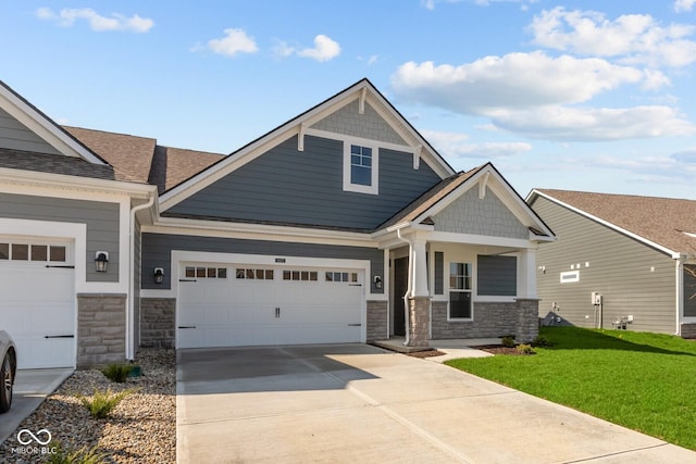 16673 Cattle Hollow Ln, Noblesville, IN 46060 - craftsman-style house with stone siding, a front lawn, an attached garage, concrete driveway, and a shingled roof