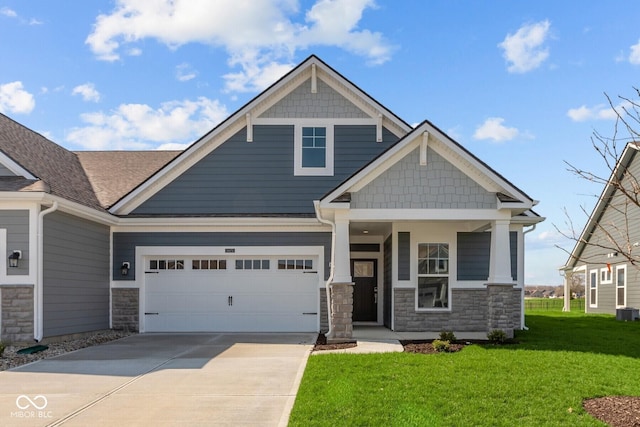 16673 Cattle Hollow Ln, Noblesville, IN 46060 - craftsman-style home with stone siding, a front lawn, driveway, covered porch, and a garage