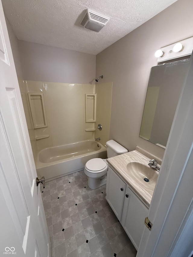 full bathroom featuring vanity, a textured ceiling, toilet, and shower / bathtub combination