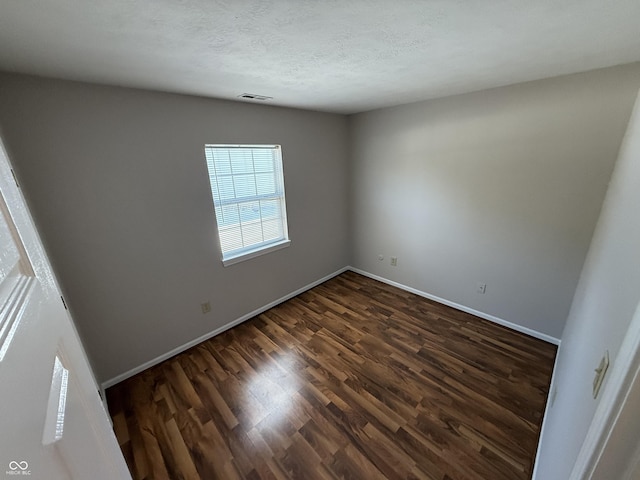 unfurnished room with dark hardwood / wood-style flooring