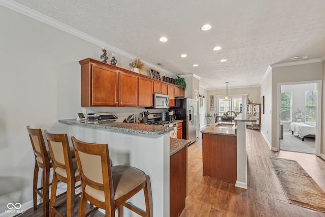 6595 Reserve Dr, Indianapolis, IN 46220 - kitchen with stainless steel appliances, a sink, ornamental molding, recessed lighting, and brown cabinets