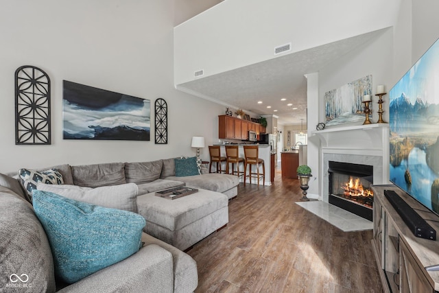 6595 Reserve Dr, Indianapolis, IN 46220 - living room featuring wood finished floors, a tiled fireplace, crown molding, and a high ceiling