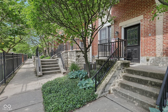 6595 Reserve Dr, Indianapolis, IN 46220 - view of exterior entry with brick siding, fence, and cooling unit