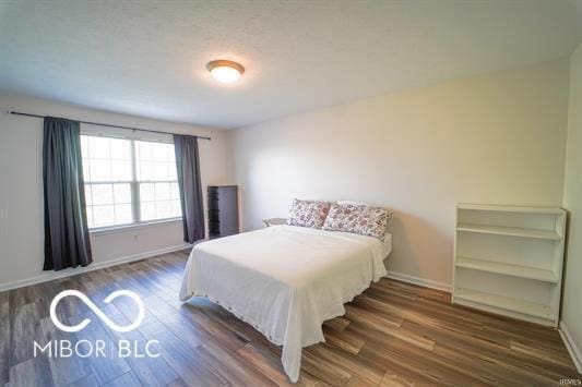 bedroom with dark hardwood / wood-style flooring