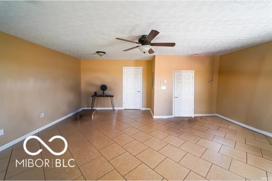 unfurnished room with light tile patterned floors, a textured ceiling, and ceiling fan