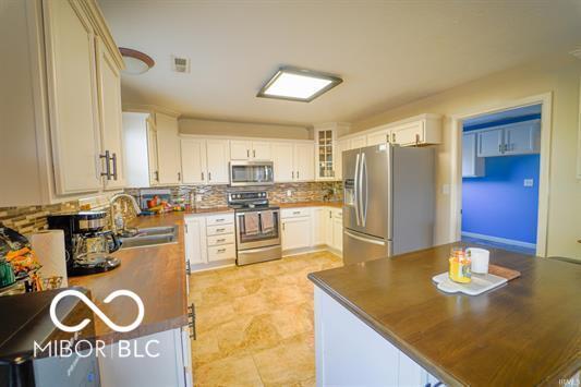 kitchen featuring white cabinets, sink, appliances with stainless steel finishes, and tasteful backsplash