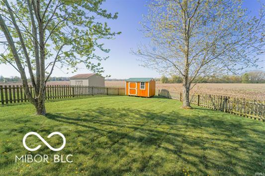 view of yard featuring a rural view and a storage shed