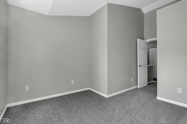 carpeted empty room featuring lofted ceiling