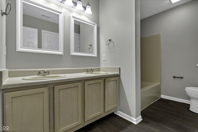 full bathroom featuring bathtub / shower combination, vanity, hardwood / wood-style flooring, and toilet