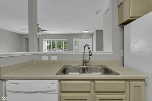 kitchen featuring ceiling fan, sink, dishwasher, a textured ceiling, and cream cabinetry