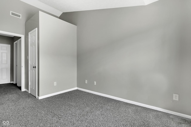 carpeted empty room with vaulted ceiling