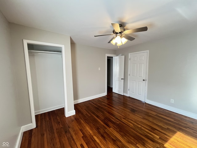 unfurnished bedroom with a closet, a ceiling fan, baseboards, and dark wood-style flooring