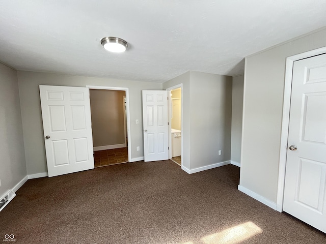 unfurnished bedroom featuring baseboards and dark carpet