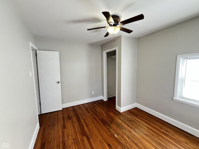 unfurnished bedroom featuring dark wood finished floors, a ceiling fan, baseboards, and a closet