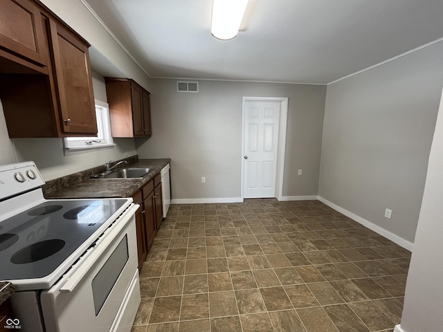 kitchen featuring visible vents, a sink, dark countertops, white appliances, and baseboards