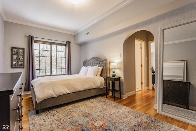 bedroom featuring ornamental molding and light hardwood / wood-style flooring