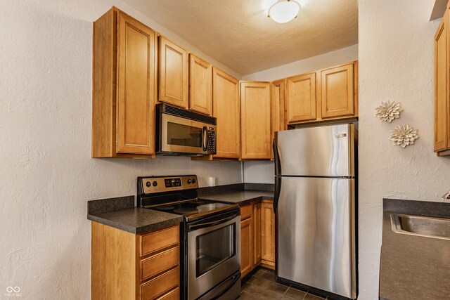 kitchen featuring appliances with stainless steel finishes, a textured ceiling, and sink