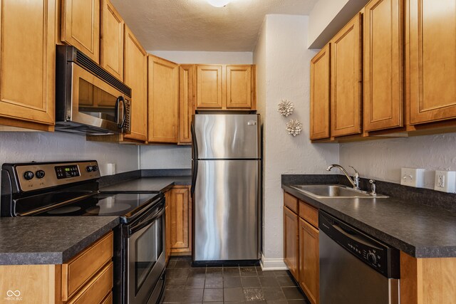 kitchen with sink, stainless steel appliances, and a textured ceiling