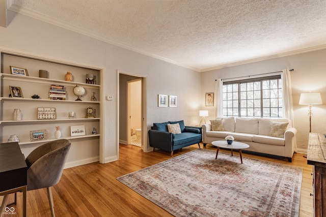 living room featuring a textured ceiling, light hardwood / wood-style flooring, and ornamental molding