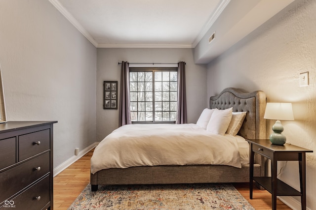 bedroom featuring light wood-type flooring and crown molding