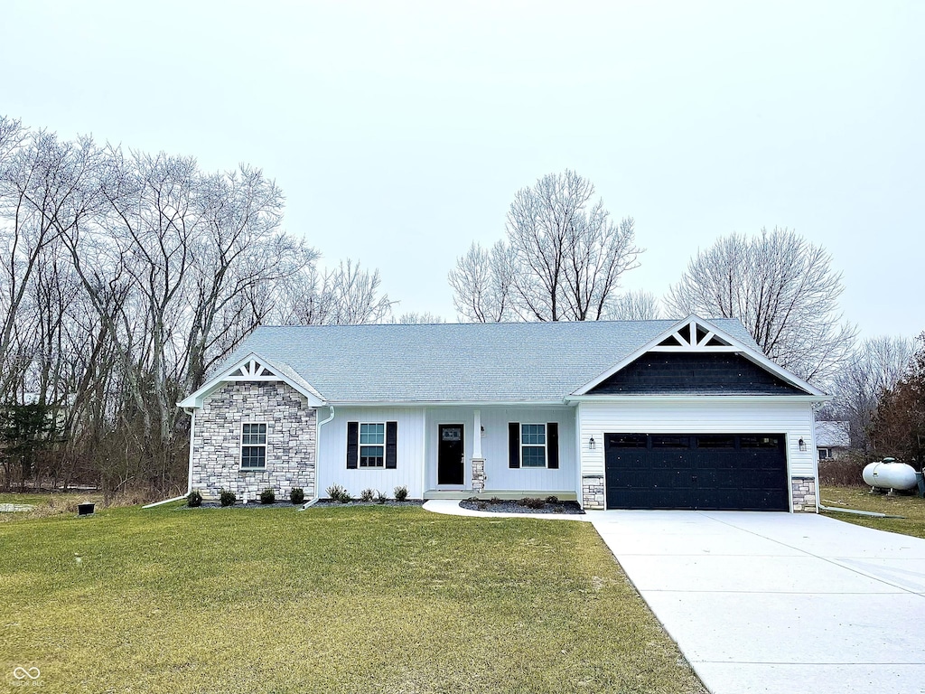 ranch-style home featuring a garage, stone siding, a front lawn, and driveway