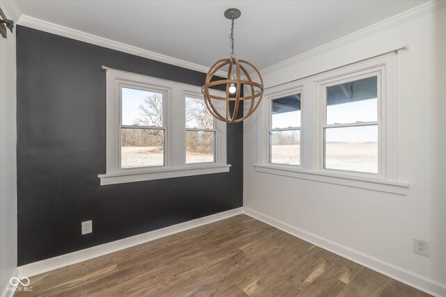 unfurnished dining area featuring crown molding, dark hardwood / wood-style floors, and a notable chandelier