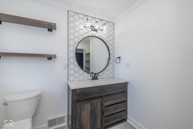 bathroom featuring vanity, toilet, and ornamental molding