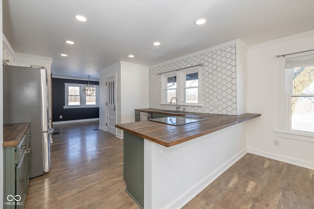 kitchen featuring white cabinets, wood counters, kitchen peninsula, and crown molding