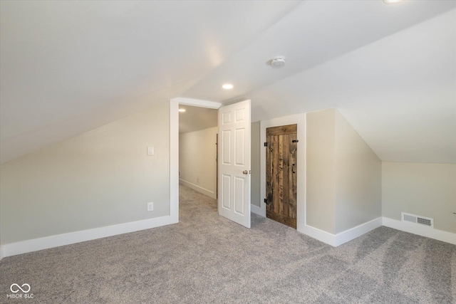 additional living space with light carpet and vaulted ceiling