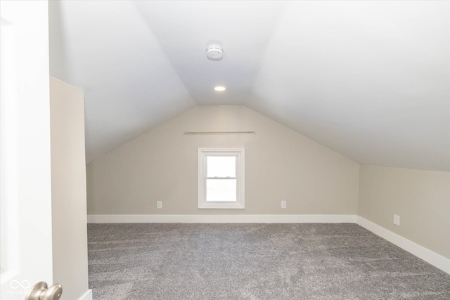 additional living space with carpet floors and vaulted ceiling