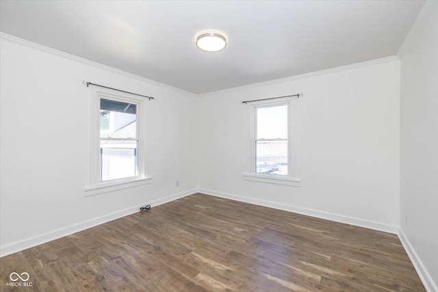 spare room with dark wood-type flooring, crown molding, and a healthy amount of sunlight