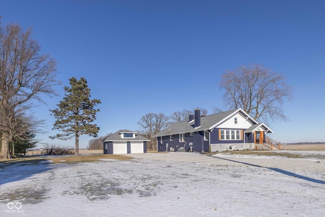 view of front of house featuring a garage and an outbuilding