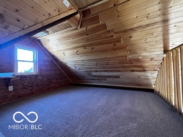 bonus room featuring dark carpet, wood ceiling, wooden walls, and vaulted ceiling