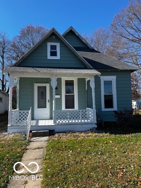 bungalow-style home with covered porch and a front yard