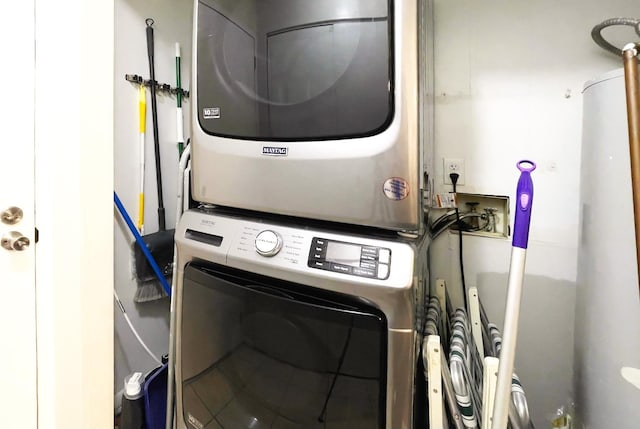 clothes washing area featuring stacked washer and clothes dryer