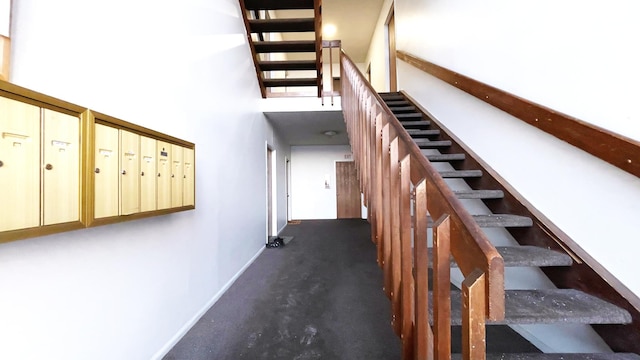 staircase with a high ceiling and mail boxes