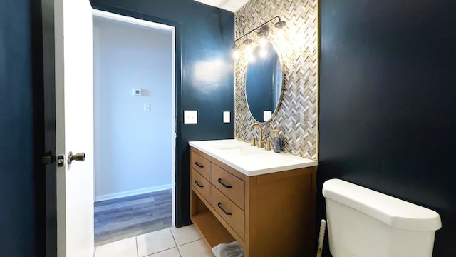 bathroom with vanity, backsplash, toilet, and tile patterned flooring