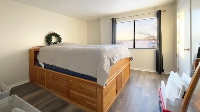 bedroom featuring dark hardwood / wood-style flooring and a textured ceiling