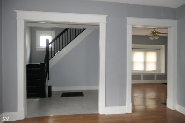 staircase featuring tile patterned floors and ceiling fan