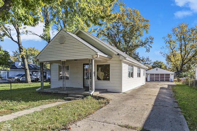 bungalow-style home with a porch, a front lawn, an outdoor structure, and a garage