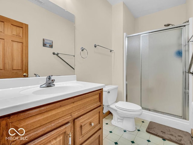 bathroom with vanity, a shower with shower door, and toilet