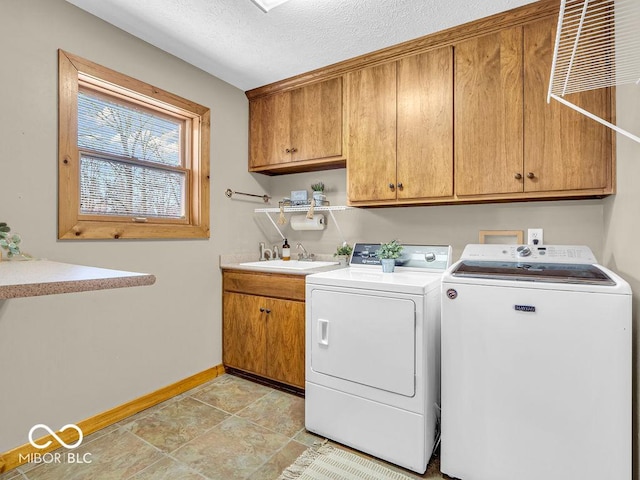 laundry area featuring cabinets, independent washer and dryer, a textured ceiling, and sink