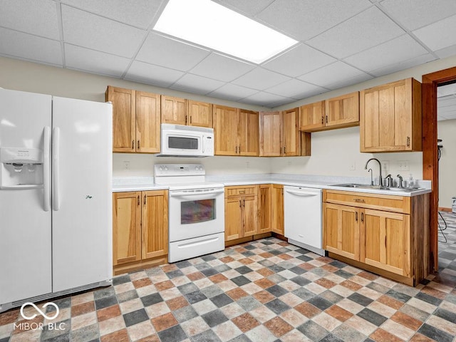 kitchen with a paneled ceiling, white appliances, and sink