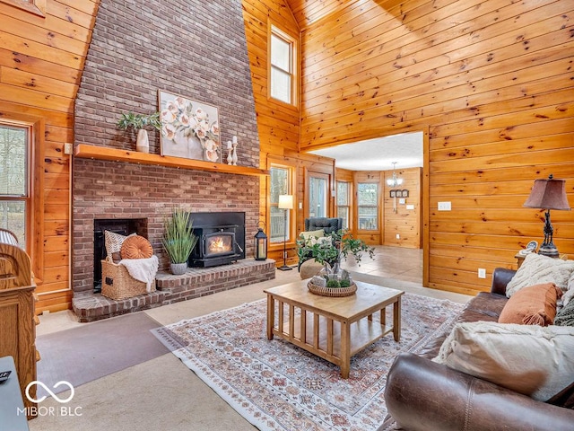 living room with a wood stove, wooden walls, and a high ceiling