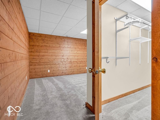 additional living space featuring carpet flooring and wood walls