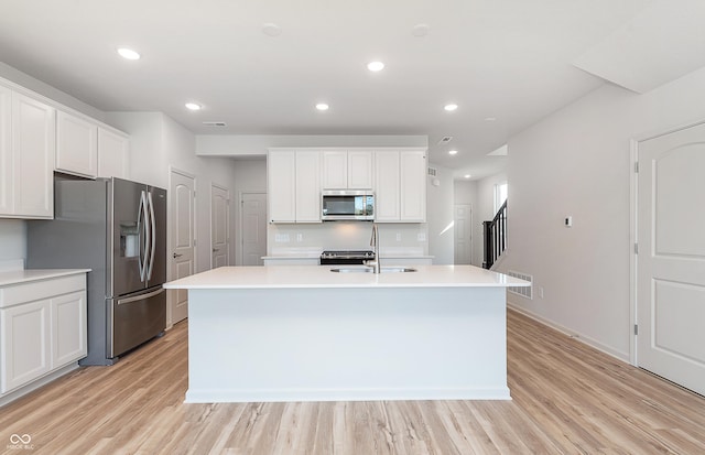 kitchen featuring sink, stainless steel appliances, light hardwood / wood-style flooring, an island with sink, and white cabinets