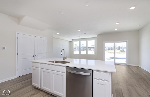 kitchen with sink, white cabinets, dishwasher, and a center island with sink