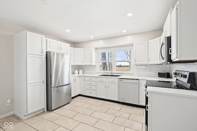 kitchen featuring tasteful backsplash, appliances with stainless steel finishes, sink, and white cabinets