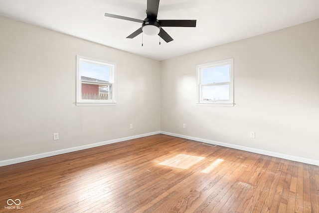 unfurnished room featuring hardwood / wood-style floors, a wealth of natural light, and ceiling fan