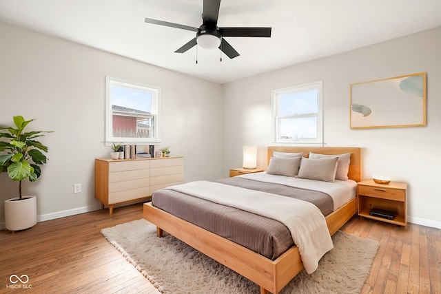 bedroom featuring multiple windows, hardwood / wood-style flooring, and ceiling fan